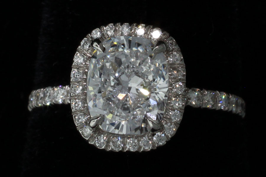 ring with a large central diamand and several round ut diamonds in a platinum setting
